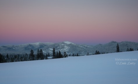 Idaho, North, Harrison.  Rural snow covered landscape, under a pink sunset sky.
