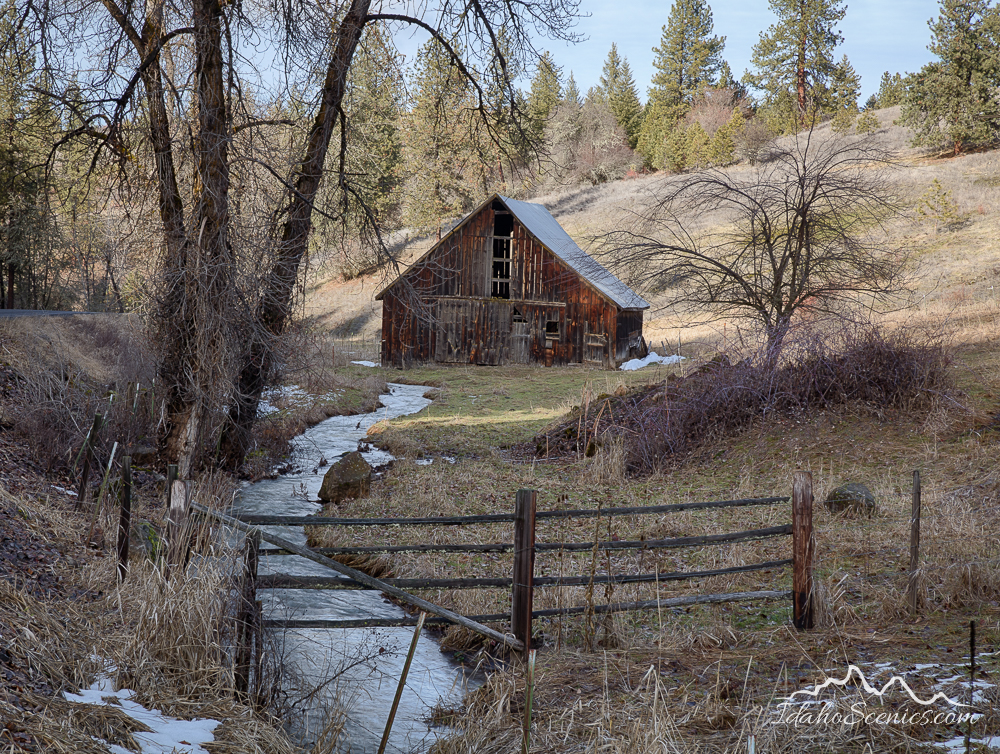 Idaho, North Central, Idaho County, Kooskia. An old barn and creek in winter.